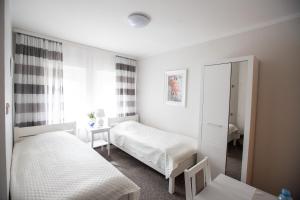 sypialnia z 2 łóżkami i lustrem w obiekcie Pensjonacik Grażyna w mieście Ełk