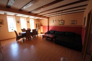 a living room with a couch and a table and chairs at Gästehaus 53 Nord in Wilhelmshaven