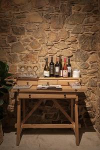 una mesa de madera con botellas de vino. en Charco Hotel, en Colonia del Sacramento