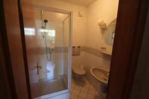 a bathroom with a shower and a toilet and a sink at Gästehaus 53 Nord in Wilhelmshaven