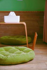 a green chair and a table with a green cushion at 墾丁辰居親子包棟民宿 in Hengchun