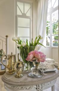 uma mesa com vasos de flores e livros sobre ela em B&B Di Camilla em Pisa