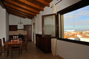 a kitchen and dining room with a table and a window at B&B L'Ancora in Porto Torres