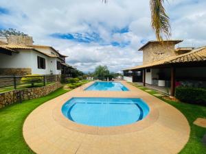 a swimming pool in a yard next to a house at Casa De Lagoa Santa in Lagoa Santa