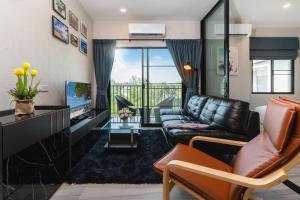a living room with a couch and a television at The Title Residencies Naiyang Beach in Nai Yang Beach +214 photos