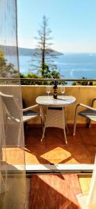 a table with two wine glasses on a balcony at Apartments "Belle Vue" in Herceg-Novi