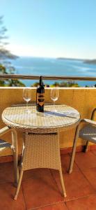 a table with two glasses and a bottle of wine at Apartments "Belle Vue" in Herceg-Novi