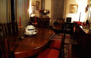 une salle à manger avec une table en bois et une chambre avec une salle à manger dans l'établissement Vila Joaninha, à Santo da Serra