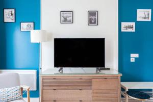 uma sala de estar com televisão numa cómoda de madeira em Magnifique studio avec Balcon-Vieux Port-Panier em Marselha