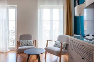 uma sala de estar com duas cadeiras e uma televisão em Magnifique studio avec Balcon-Vieux Port-Panier em Marselha