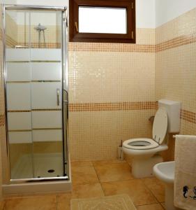 a bathroom with a toilet and a glass shower at B&B L'Ancora in Porto Torres +25 photos