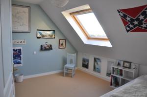 a attic bedroom with a skylight and a bed at Maison d'Aude in Brignogan-Plage