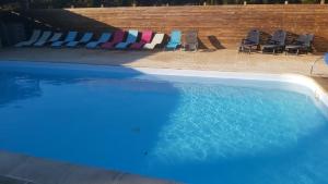 una piscina con sillas y una piscina en Domaine de la Tarais, en Calorguen