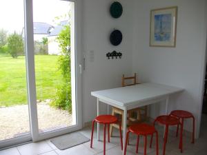 a white table and four red stools in a room at Maison d'Aude in Brignogan-Plage +31 photos