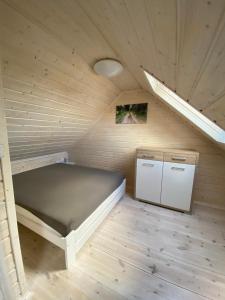 Mały pokój z łóżkiem i lodówką w obiekcie Domek Helenka w mieście Stężyca