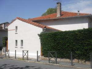 ein weißes Gebäude mit einer Hecke neben einer Straße in der Unterkunft La Maisonnette de l'échappée verte. in Albi