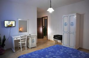 a bedroom with a bed and a desk and a mirror at B&B L'Ancora in Porto Torres