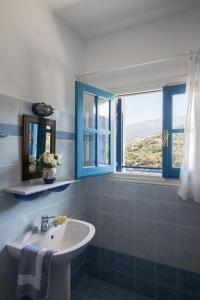 a bathroom with a sink and blue windows at Sea View Kerame in Évdhilos