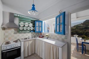 a kitchen with blue cabinets and a sink and a stove at Sea View Kerame in Évdhilos