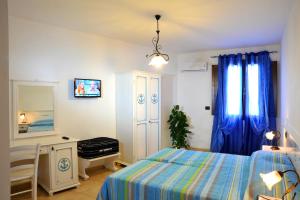 a bedroom with a bed and a table and a mirror at B&B L'Ancora in Porto Torres