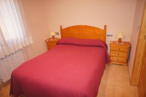 コルノデイヤにあるCa La Paletesのベッドルーム1室(赤いベッド1台、ナイトスタンド2台付)