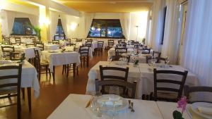 a restaurant with tables and chairs with white tablecloths at Sogno Sulcitano Masainas in Masainas +264 photos