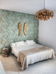 a bedroom with a large bed with angel wings on the wall at El Patio de San Bernardo in Seville