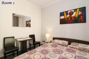 a bedroom with a bed and a table and a painting at Old Town Rooms and Apartment in Poreč