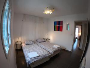 阿雅克肖的住宿－LA TERRASSE DE SAINT-JEAN，卧室配有一张床,墙上挂有绘画作品