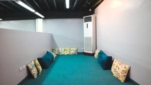 a room with a couch, chairs and a table at Nomad's Hub - Best Value Co-living Hostel in Cebu City