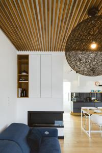 a living room with a blue couch and a wooden ceiling at Bosky Apartament in Gródek Nad Dunajcem