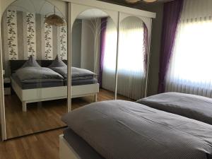 1 Schlafzimmer mit 2 Betten und einem Spiegel in der Unterkunft Ferienwohnung Eifelluft in Daun