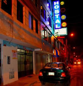 a car parked in front of a building at night at Passion Hostel - Lima Airport in Lima