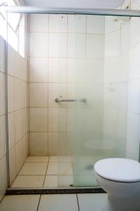 a bathroom with a glass shower with a toilet at Hotel Iguacu in Campo Grande