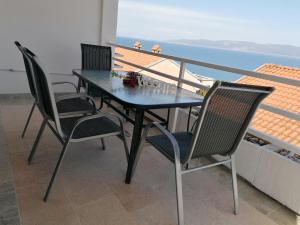 a table and chairs on a balcony with a view at 4 Roses Apartment in Ravni