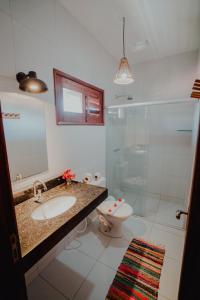 a bathroom with a toilet and a sink and a shower at Villa Aurora in Flecheiras