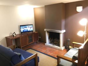 sala de estar con chimenea y TV en Quinta Travessa, en Vieira do Minho