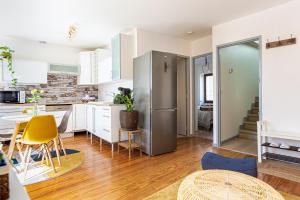 uma cozinha com armários brancos e um frigorífico de aço inoxidável em Duplex lumineux 2 chambres centre zone piétonne em Valence