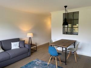 ein Wohnzimmer mit einem Sofa und einem Tisch in der Unterkunft Sylthaus - Appartement in Archsum