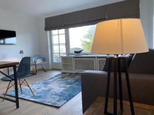 ein Wohnzimmer mit einem Sofa und einer Lampe in der Unterkunft Sylthaus - Appartement in Archsum