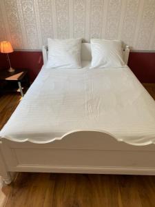 a large white bed with white sheets and pillows at Maison calme à Beaune in Beaune