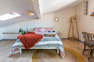 a bedroom with a bed with a red and blue blanket at Duplex lumineux 2 chambres centre zone piétonne in Valence