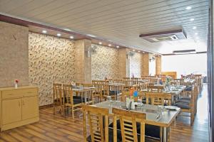 Mughal SarāiSpring Sky Mughalsarai By ShriGo Hotels的一间有桌椅的餐厅