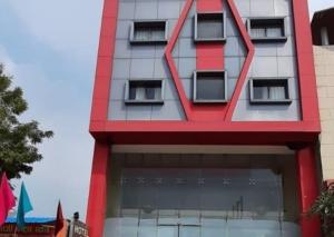 a tall red building with a window at Spring Sky Mughalsarai By ShriGo Hotels in Mughal Sarāi