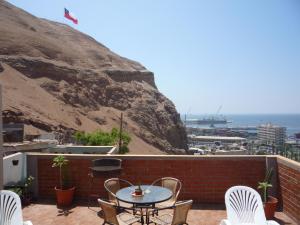 a patio with a table and chairs and a mountain at Le Petit Clos in Arica