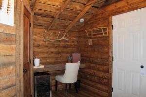 a room with a white chair in a wooden wall at Elkhorn Cabins and Inn in West Yellowstone