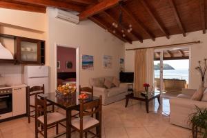 a kitchen and living room with a table and chairs at Yiannis Seafront Villa Paleokastritsa in Paleokastritsa