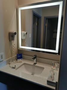 a bathroom with a mirror and a sink at Comfort Inn and Suites University in Calgary