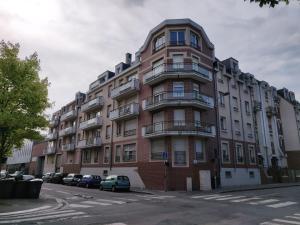 a tall building with cars parked in front of it at Appart'HomeCity - Rouen Lessard in Rouen