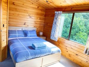 ein Schlafzimmer mit einem Bett in einem Blockhaus in der Unterkunft Lake view family Lodge up tp 14 people in Rotorua